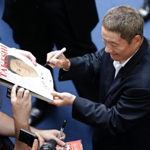 Diretor japonês Takeshi Kitano dá autógrafos durante a divulgação de seu novo filme, "Outrage Beyond" (3/9/12) - Max Rossi/Reuters