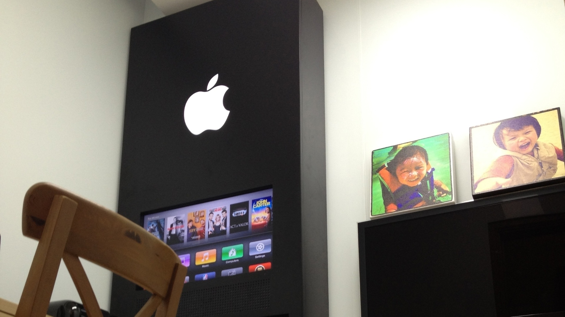 O chinês David Wu fez uma réplica de uma Apple Store em seu escritório em casa. No detalhe, um painel com um televisor ligado a uma Apple TV e prateleiras com caixas de produtos da Apple - DavidWu.me/Reprodução