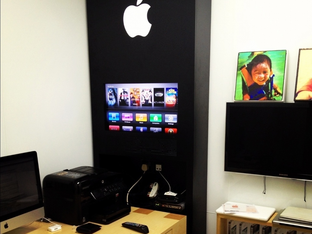O chinês David Wu fez uma réplica de uma Apple Store em seu escritório em casa. No detalhe, um painel com um televisor ligado a uma Apple TV e prateleiras com caixas de produtos da Apple - DavidWu.me/Reprodução