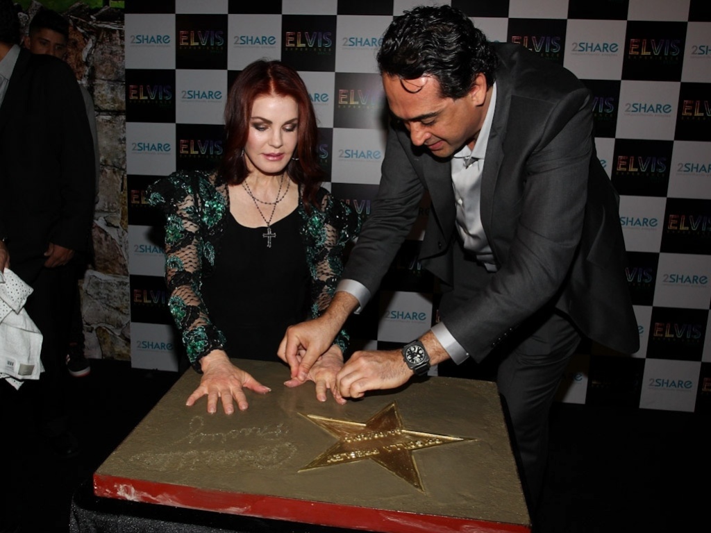 Priscilla Presley assina e deixa a marca de suas mãos em placa com a ajuda de Rafael Reisman, presidente da 2Share Entertainment, produtora responsável pela vinda da exposição ao Brasil (4/9/12) - Manuela Scarpa/Foto Rio News