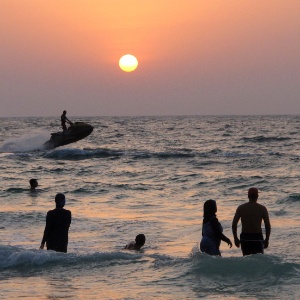 Banhistas aproveitam praia de Dubai durante o pôr do sol - AP Photo/Hassan Ammar