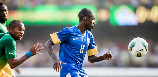 Observado por dois sul-africanos, Ramires tenta a jogada durante amistoso da seleção