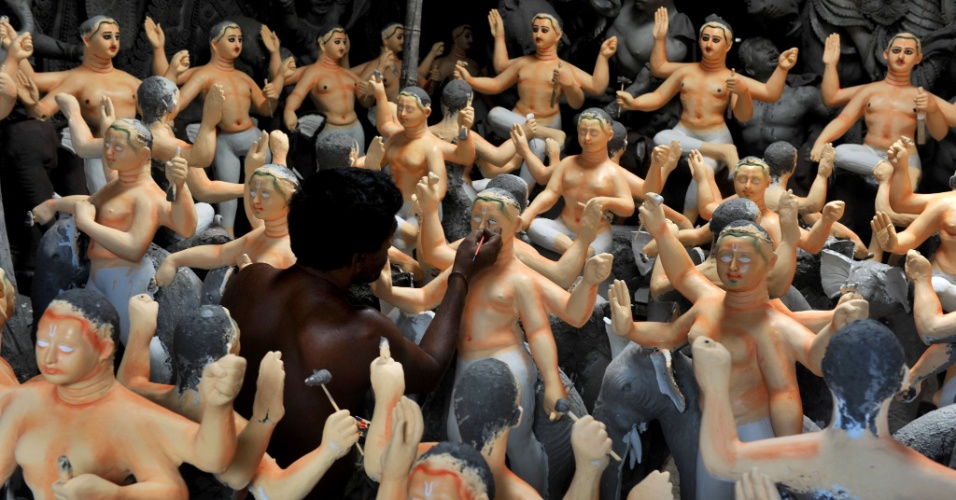 10.set.2012 - Artista indiano pinta figuras da divindade Biswakarma, na vila de Kumartoli, em Siliguri (Índia)