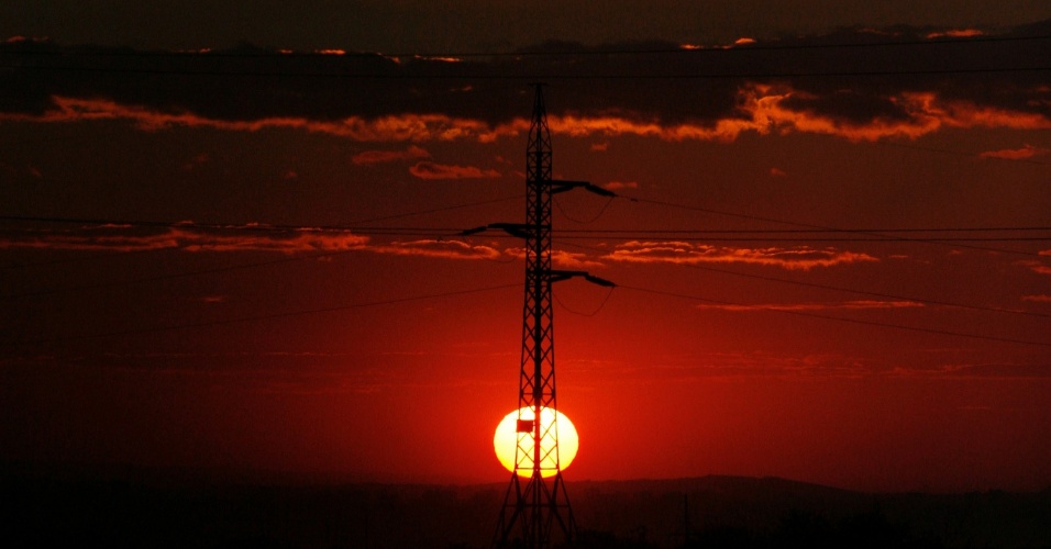 10.set.2012 - Sol é visto através de poste de energia nos subúrbios da cidade Krasnoyarsk, na Rússia