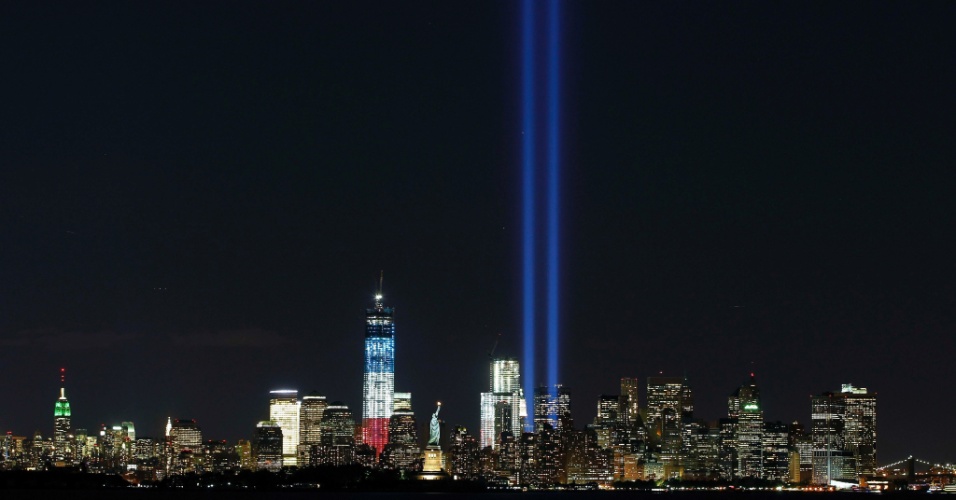 11.set.2012 - Dois potentes feixes de luz são ligados próximos à estátua da Liberdade e ao edifício One World Trade Center, em Nova York (EUA), para relembrar os onze anos dos ataques terroristas contra o World Trade Center