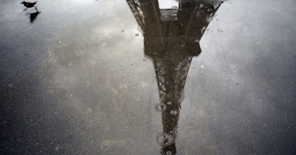 11.set.2012 - Imagem da torre Eiffel refletida em poça d'água, em dia chuvoso de Paris, na França