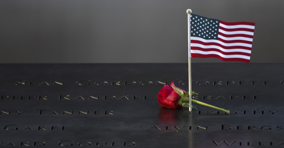 11.set.2012 - Rosa vermelha e bandeira americana são colocadas sobre inscrições de nomes de vítimas dos ataques de 11 de setembro, em memorial, no World Trade Center, em Nova York