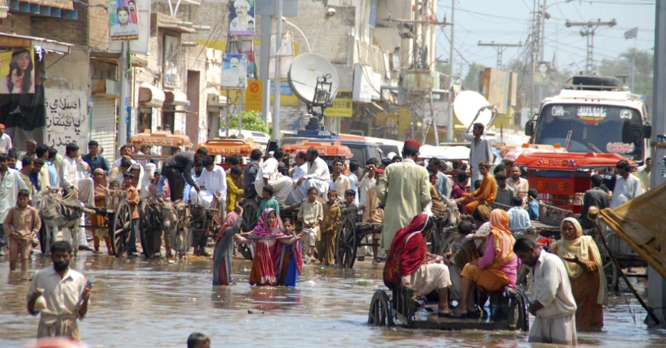 12.set.2012 - Pessoas passam por rua inundada nesta quarta-feira (12) em Shikarpur, na província paquistanesa de Sindh. As chuvas de monções deixaram ao menos 80 mortos e centenas de desalojados no Paquistão