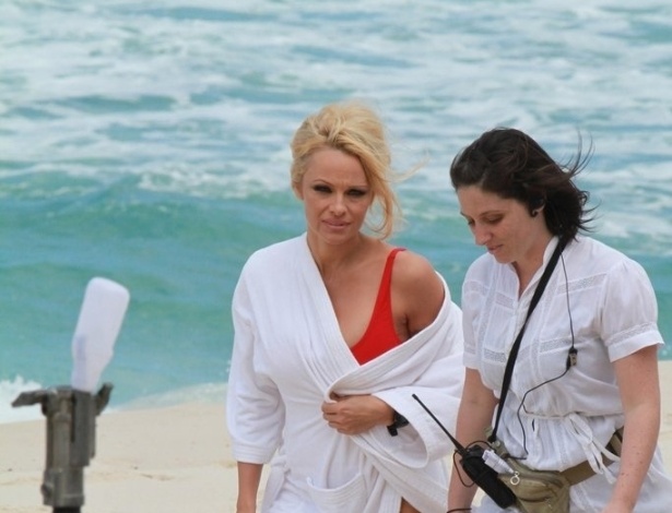 Com maiô vermelho, igual ao que usava em "SOS Malibu", a atriz Pamela Anderson gravou um comercial em praia do Rio de Janeiro (14/9/12)