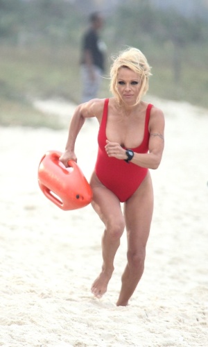 Com maiô vermelho, igual ao que usava em "SOS Malibu", a atriz Pamela Anderson gravou um comercial em praia do Rio de Janeiro (14/9/12)