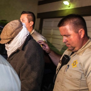 Homem não-identificado é escoltado pela polícia para fora da residência de Nakoula Basseley Nakoula, em Los Angeles (15/9/12) - Bret Hartman/Reuters