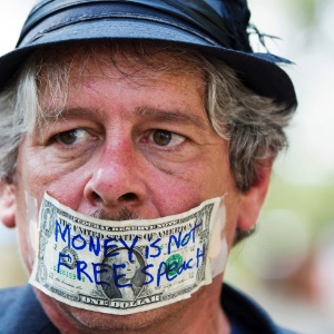 Ativista do Occupy Wall Street tampa a boca com dólar durante protesto realizado em Nova York para marcar o primeiro aniversário do movimento. Imagem de 17/09/2012 - Lucas Jackson/Reuters 