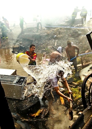 Moradores usam balde para apagar foco de incêndio na favela do Moinho, em São Paulo - Leandro Moraes/UOL