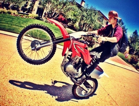 O cantor canadense Justin Bieber publicou uma foto no Instagram nesta segunda-feira (17) na qual aparece empinando uma moto. Na legenda da imagem, o cantor escreveu "não brinque", em alusão ao perigo da manobra que realizou com o veículo de duas rodas (17/9/12)