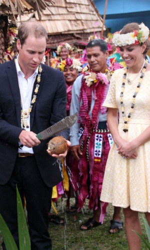 Ao lado de Kate, príncipe William corta um coco ao meio na Ilha Nanumea, na vila de Tuvalu (18/9/12)