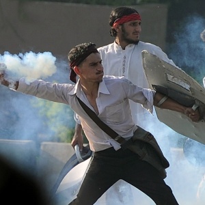 Manifestante paquistanês atira bomba de gás lacrimogêneo em protesto contra filme anti-Islã (20/9/12) - Aamir Qureshi/AFP