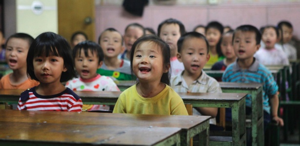 Crianças recitam cartas em inglês durante aula em escola para filhos de trabalhadores migrantes, em Pequim, na China - Jason Lee/Reuters