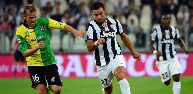 Fábio Quaglierella, da Juventus, carrega a bola com a marcação de Luca Rigoni, do Chievo, em partida do Campeonato Italiano - AFP PHOTO / OLIVIER MORIN