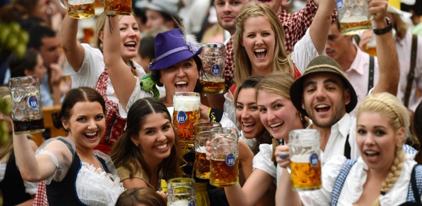 Visitantes com trajes típicos da Bavária brindam com seus canecos de cerveja ao início da Oktoberfest, em Munique (22/09/2012) - Christof Stache/AFP