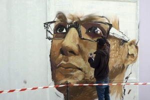 Grafiteiro pinta rosto de morador do centro de Paris em muro da cidade (22/9/12) - EFE