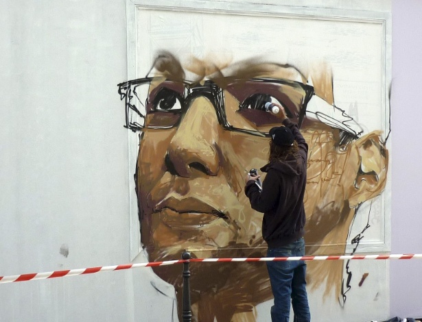 Grafiteiro pinta rosto de morador do centro de Paris em muro da cidade (22/9/12) - EFE