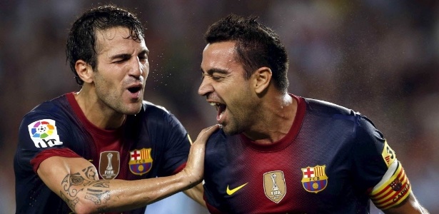 Fábregas e Xavi comemoram gol do Barcelona contra o Sevilla - Alberto Estévez/EFE