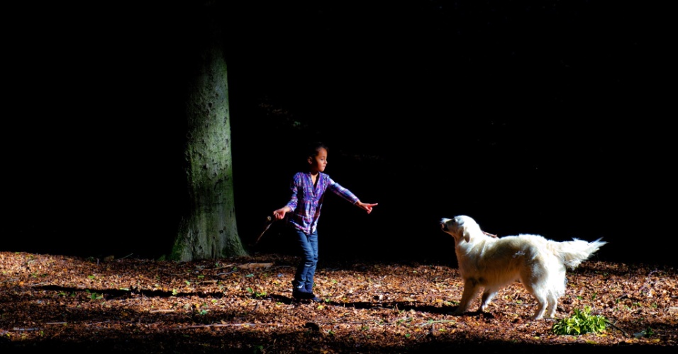 30.set.2012 -  Garota brinca com seu cachorro em floresta na Holanda