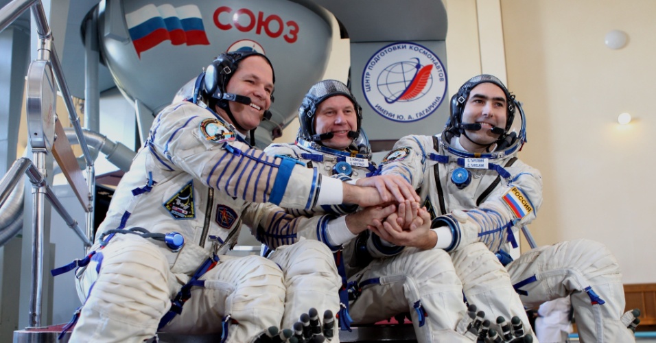 01.out.2012 - Os astronautas Kevin Ford, Oleg Novitskiy e Evgeny Tarelkin, da esquerda para direita, posam para fotos na frente da nave Soyuz após última sessão de testes qualificatórios no centro de treinamento Cosmonauta Gagarin, na Rússia. O trio viajará ao espaço no próximo dia 23 para passar para cinco meses na Estação Espacial Internacional (ISS, na sigla em inglês)