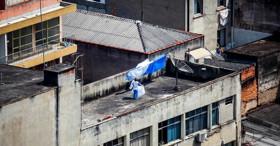 2.out.2012 - Mulher aproveita o clima seco para pendurar roupas para secar, próximo ao vale do Anhangabaú, no centro de São Paulo. Às 16h00, o CGE registrava 29°C e 45% de umidade relativa do ar