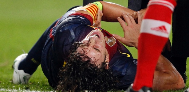 Puyol, do Barcelona, sente dor após lesionar o braço durante partida contra o Benfica - Jose Manuel Ribeiro/Reuters