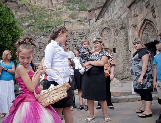 Família durante os preparativos para cerimônia religião em mosteiro de Geghard, Armênia - Justyna Mielnikiewicz/ The New York Times