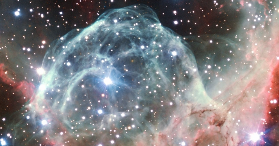 5.out.2012 - Para comemorar seus 50 anos, o Observatório Europeu do Sul (ESO, na sigla em inglês) fez imagens da nebulosa Elmo de Thor, após escolha do público. Também conhecida por NGC 2359, a nuvem de poeira é uma maternidade estelar na constelação Cão Maior, a cerca de 15 anos-luz de distância da Terra.  Sua forma de capacete surgiu a partir do vento da estrela de grande massa (ponto brilhante mais próximo do centro) que se desloca através da nuvem molecular soprada para a bolha cósmica. A estrela também emana radiação e aquece os diferentes gases ao seu redor, reação que dá a nuance de cores na nebulosa