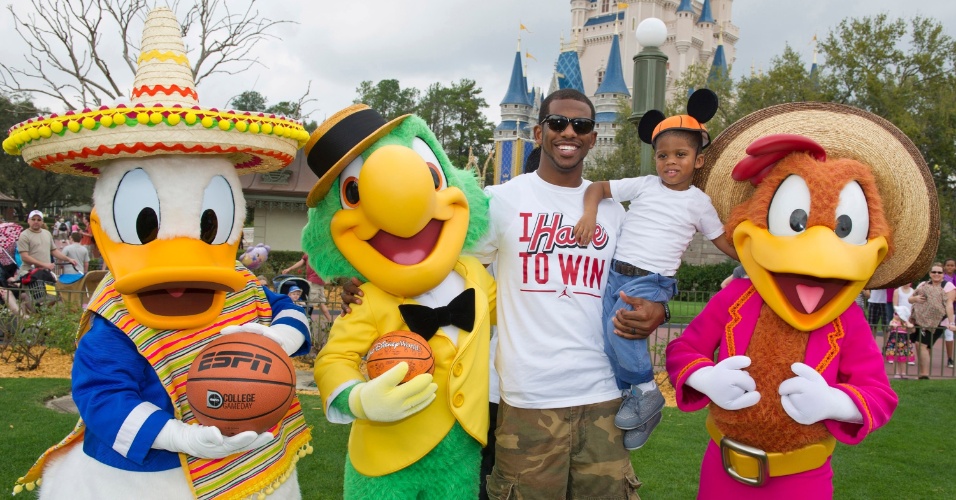 Chris Paul, jogador do Los Angeles Clippers, e seu filho Chris tiram fotos com personagens da Disney durante viagem ao parque em Orlando (23/02/2012)