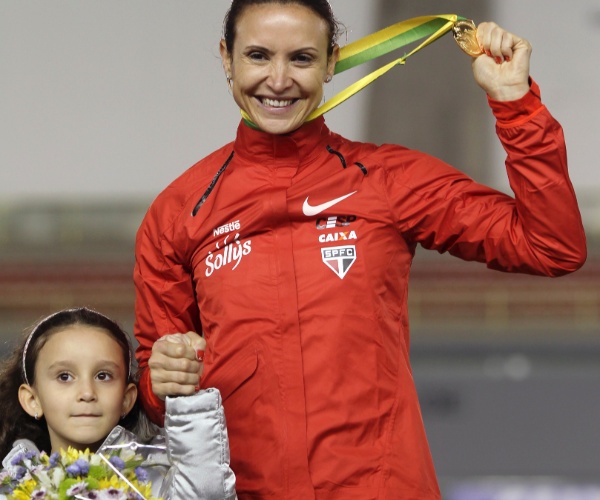 Maurren Maggi sobe ao pódio com a filha, Sofia, para receber o ouro do GP Brasil de atletismo (16/05/2012)