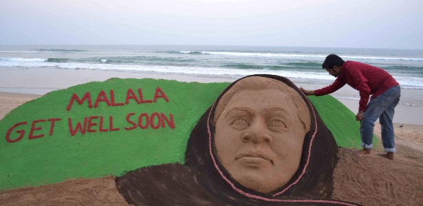 Artista indiano faz retoques finais em escultura de areia em homenagem a Malala Yousufzai - STR/AFP