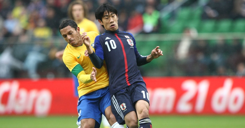 O lateral brasileiro Adriano tenta tirar a bola do rival japonês 