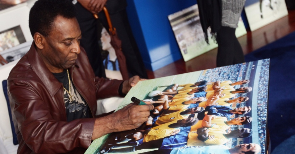 Pelé assina um pôster da seleção brasileira durante sua visita ao Museu dos Campeões; o Rei do futebol acompanhou a premiação Golden Foot 2012 (17/10/2012)