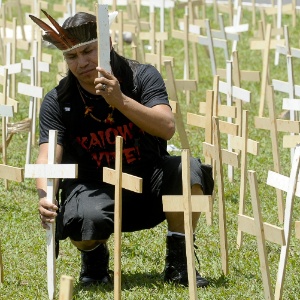 Um índio guarani-kaiowá coloca uma cruz simbolizando os mortos em frente ao Congresso Nacional - Wilson Dias/Agência Brasil