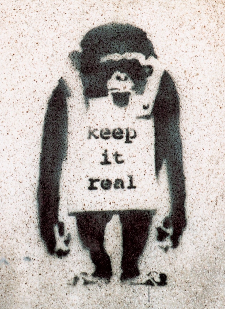 Assim como os ratos, os macacos com mensagens no peito sempre são vistos nas obras de Banksy. Outra versão conhecida é "Laugh Now, but one day we'll be in charge" (você sorri agora, mas um dia nós estaremos no comando)  - Divulgação