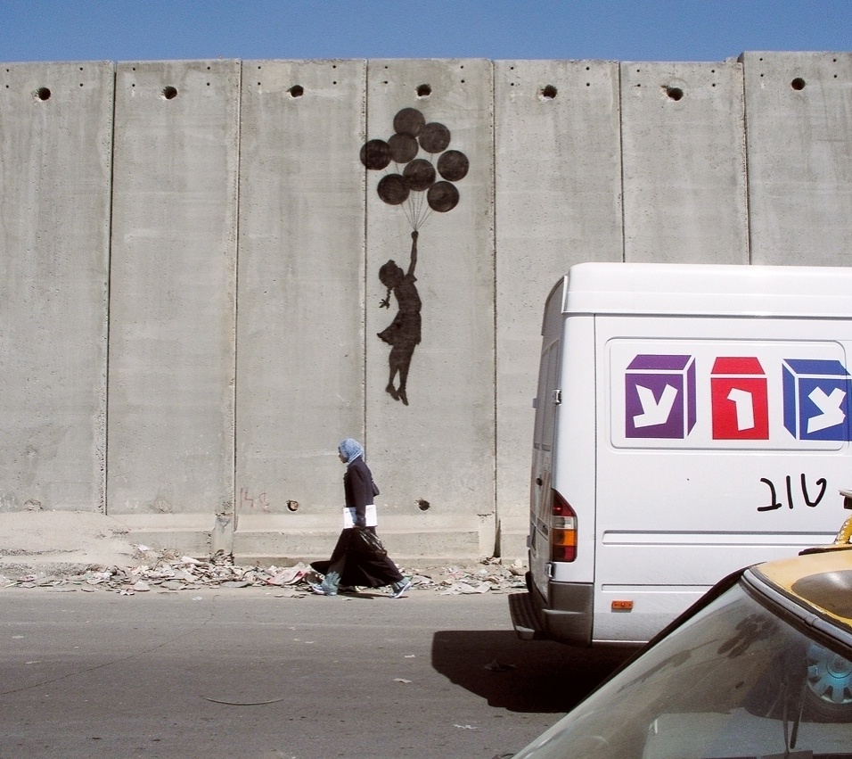 Obra de Banksy pintada em muro de Belém, em 2005. O livro narra a conversa do artista com um idoso. O idoso pergunta: "Você pintou o muro, ele ficou bonito". "Obrigado", respondeu Banksy. "Não queremos que esse muro fique bonito, nós odiamos esse muro, vá embora"  - Divulgação