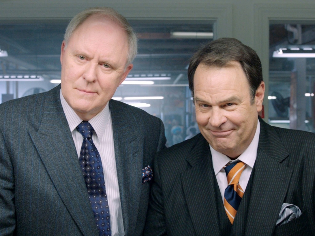 Os irmãos Motch (John Lithgow e Dan Aykroyd) financiam a campanha de Huggins com o objetivo de lucrar com indústrias que exploram trabalhadores - Divulgação