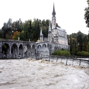20.out.2012 - Após chuvas, rio na França fica próximo de transbordar; ao fundo, basílica na cidade de Lourdes - Laurent Dard/AFP