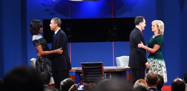 Barack Obama (à esq.) e Mitt Romney recebem suas mulheres, Michelle e Ann, no palco ao final do debate - Saul Loeb/AFP