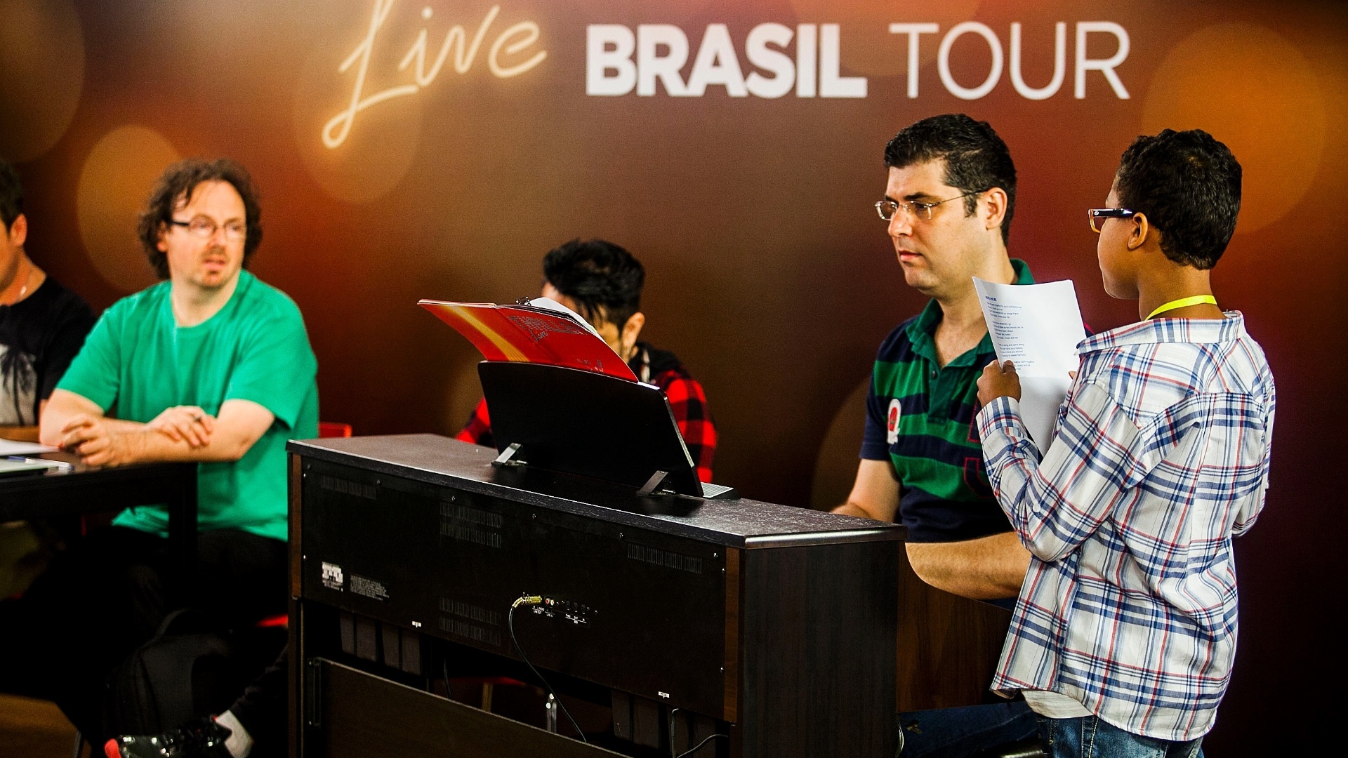 Jean Lucas, de 11 anos, chegou decidido, pediu a nota para o pianista que estava auxiliando os candidatos e se apresentou para os jurados. De verde, o produtor musical John Maher - Leonardo Soares de Souza/ UOL