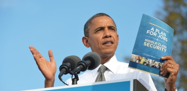  O Presidente dos Estados Unidos e candidato à reeleição, Barack Obama, mostra cópia do seu plano de geração de empregos durante evento de campanha em Dayton, Ohio (EUA) - Mandel Ngan/AFP