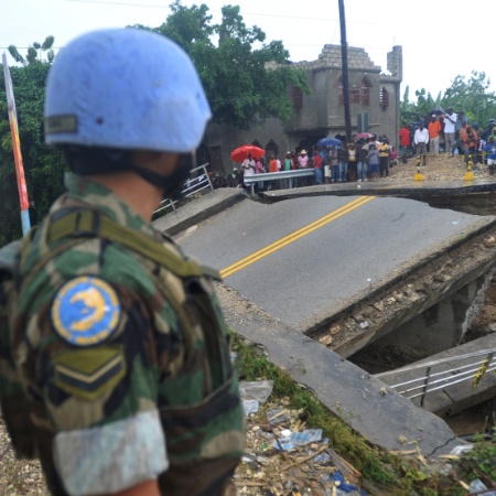 Agente da ONU observa ponte destruída por furacão no Haiti, em 2012 - Thony Belizaire/AFP