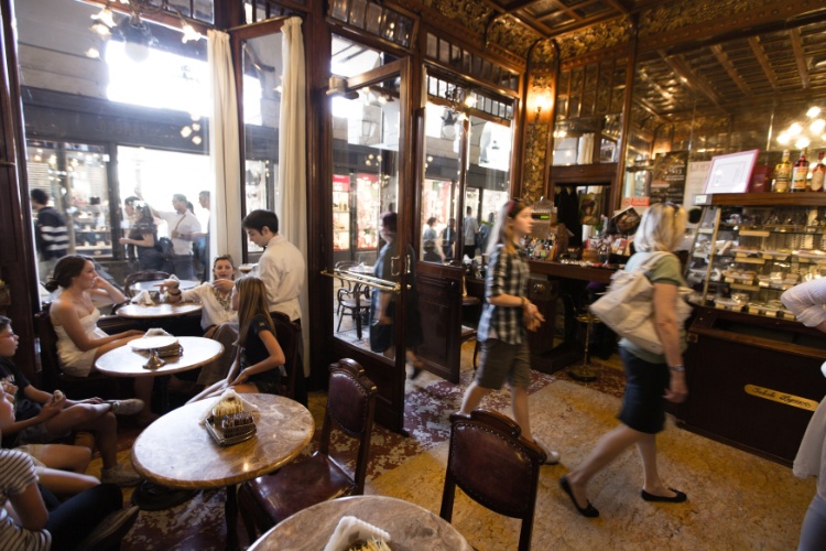 Existem poucas mesas no Caffè Mulassano, local de pé direito alto e parede espelhada