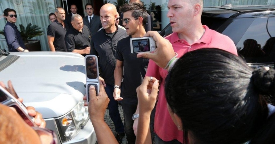 No Brasil para divulgar "Amanhecer - Parte 2", o ator Taylor Lautner se despede dos fãs cariocas, posando para fotos em frente ao hotel em que ficou hospedado (25/10/12)