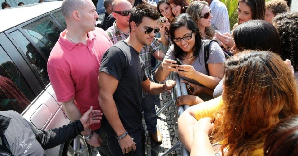 No Brasil para divulgar "Amanhecer - Parte 2", o ator Taylor Lautner se despede dos fãs cariocas, posando para fotos em frente ao hotel em que ficou hospedado (25/10/12)