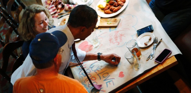 O presidente Barack Obama autografa tolha de mesa na qual apoiadores de sua campanha escreveram "Nós te amamos, Barack", em restaurante em Merrimack, em New Hampshire